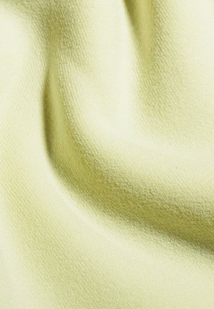 Tessuto giallo chiaro con superficie morbida e testurizzata, che mostra una leggera costina e pieghe, indicando un materiale leggero e accogliente.