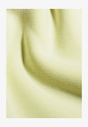 Tessuto giallo chiaro con superficie morbida e testurizzata, che mostra una leggera costina e pieghe, indicando un materiale leggero e accogliente.