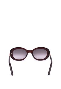 Lunettes de soleil ovales marron avec verres à dégradé foncé et branches légèrement incurvées sur fond blanc.