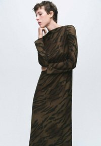 Vestido de mangas largas en marrón con rayas de tigre negras, elaborado en tejido ligero; presenta un escote alto y una silueta recta.