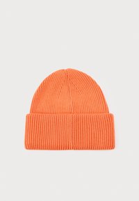 Oranssi neulepipo, jossa on poimutettu pinta ja taitettu reuna. Ylhäällä on sileä, kapeneva muoto.