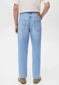 Jeans dritti blu chiaro con una finitura sbiadita, dotati di due tasche posteriori e una toppa in pelle marrone sulla vita.