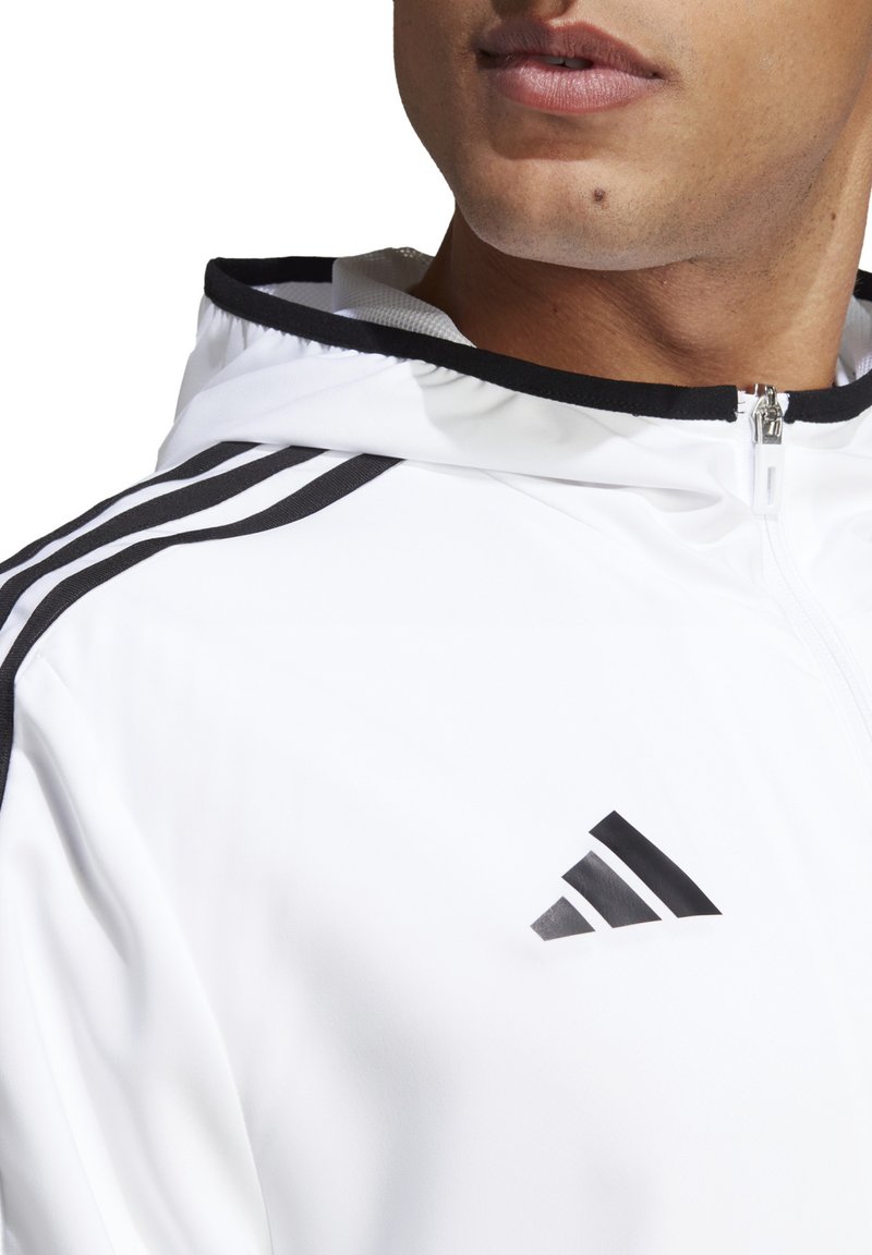 Weißer Reißverschluss-Hoodie aus glattem Stoff, mit schwarzen Akzenten und drei schwarzen Streifen auf der Schulter. Auffälliges Markenlogo sichtbar.
