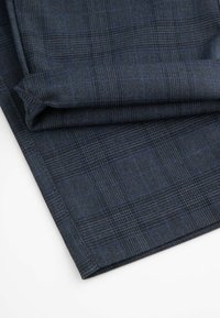 Ciemnoniebieska tkanina z subtelnym wzorem w kratę. Gładka tekstura, złożone krawędzie oraz delikatny splot z kontrastującymi jasnoniebieskimi liniami.