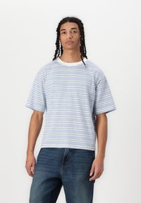 T-shirt à manches courtes, col rond, en bleu clair avec des rayures horizontales bleu marine et blanches. Matière en mélange de coton avec une coupe décontractée.