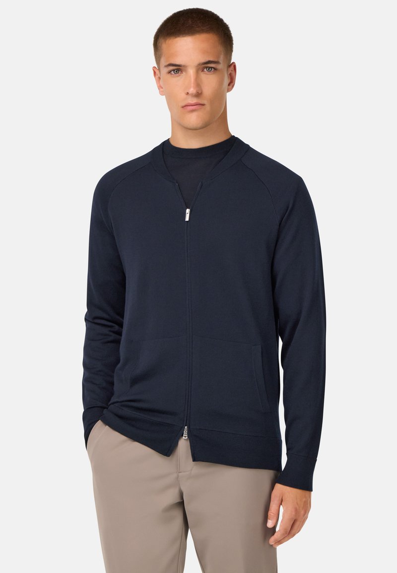 Maritimni zip up kardigan iz gladkega materiala, z rebrastim ovratnikom, dolgimi rokavi in dvemi sprednjimi žepi; prilagojen dizajn z čistim zaključkom.