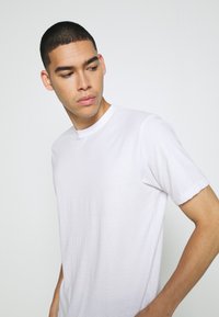 Weißes Kurzarm-T-Shirt mit Rundhalsausschnitt, aus leichtem Stoff, mit einer glatten Textur und einem lässigen Schnitt.