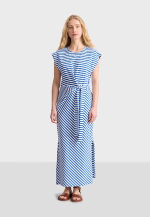 Gestreiftes Maxikleid aus blauem und weißem Baumwollstoff, mit kurzen Ärmeln, einem gebundenen Taillenband und seitlichen Schlitzen für mehr Bewegungsfreiheit. Flache Sandalen sind ausgestellt.