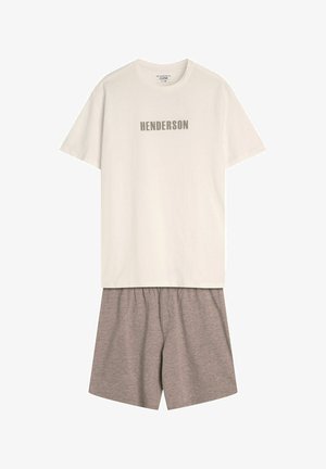 Jasno beżowa bawełniana koszulka z napisem "HENDERSON" w odcieniu szarości, w zestawie z szarymi bawełnianymi szortami z elastycznym pasem. Prosty, codzienny design.