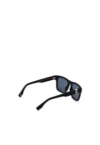 Lunettes de soleil rectangulaires noires avec verres foncés et petit logo décoratif doré sur les branches, vues d’un angle arrière.