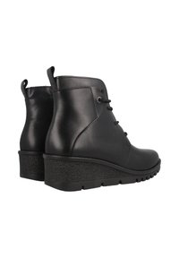 Botas de cuero negro hasta el tobillo con punta redondeada, textura suave, diseño de cordones y suela en cuña texturizada. Presenta tiradores en el talón.