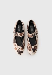Pair of leopard print Mary Jane shoes with buckled straps, black insoles labeled "Call It Spring" and "vegan," on a white background.