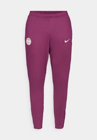Lila sportnadrág, slim fit szabással, elasztikus derekkal és oldalsó csíkozással. A PSG logó és a Nike pipa fehér színben található rajta.