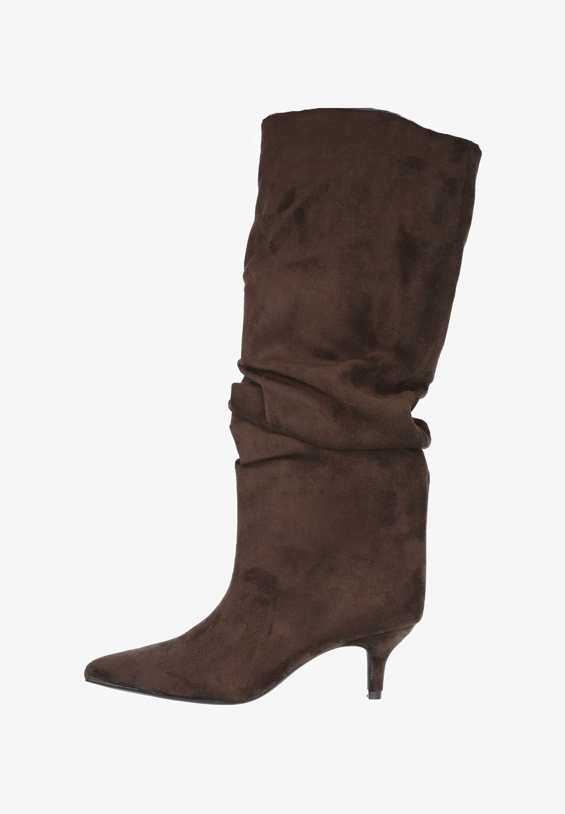 Bota alta hasta la rodilla de ante marrón con diseño holgado, punta puntiaguda y tacón delgado. El material tiene una textura suave sin adornos visibles.