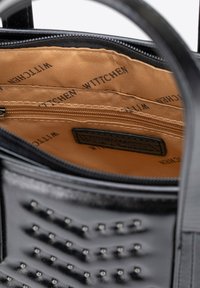 Borsa a tracolla in pelle nera con chiusura a zip, presenta un interno in tessuto color cuoio, più scomparti e dettagli con borchie sull'esterno.