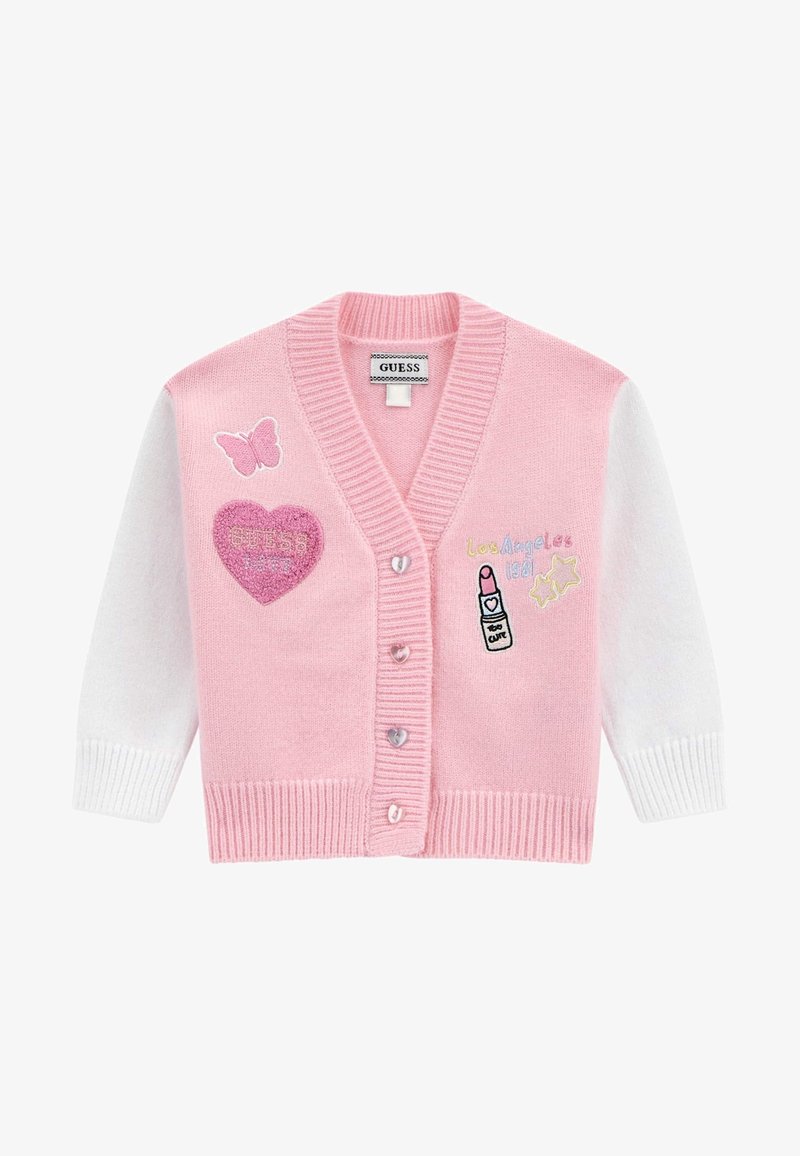 Rozā kardigans ar baltām piedurknēm, kuram ir izšūti akcenti, tostarp tauriņš, sirds un lūpu krāsa. Pogas ir sirds formas.