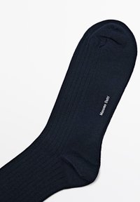 Marinblå ribbede sokker lavet af blødt materiale, med lukket tå og trykt brandnavn "Massimo Dutti" nær anklen.