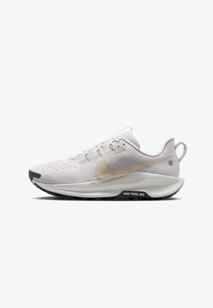 White athletic shoe in mesh material with a metallic gold Nike swoosh, black outsole, and textured detailing on the upper and heel.