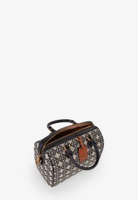 Borsa in tela con motivo geometrico, dettagli in pelle nera, accessori in oro e una targhetta in pelle marrone. Doppi manici e chiusura a zip.