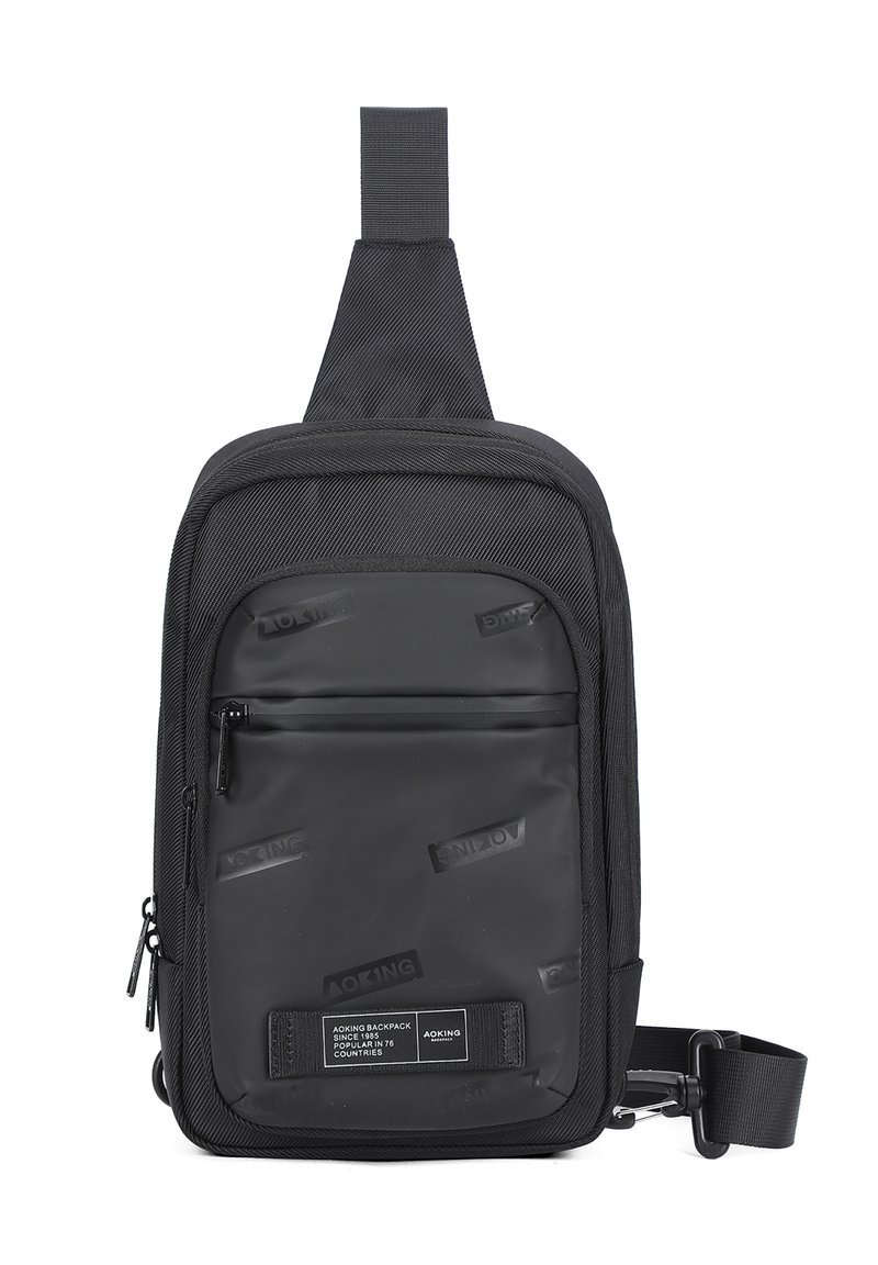 Borsa a tracolla nera realizzata in materiale resistente, con un pannello frontale liscio e loghi in rilievo, cinturino regolabile e scomparti con zip.