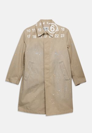 Bež kaput dužine do koljena s raširenim ovratnikom, skrivenim kopčanjem na gumbe sprijeda, bočnim džepovima i suptilnim višebojnim mrljama od boje.