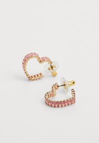 Auksinės auskarai širdies forma, papuošti rožiniais brangakmeniais. Su raštuotais akcentais ir skaidriais auskarų laikikliais, užtikrinančiais saugų dėvėjimą.