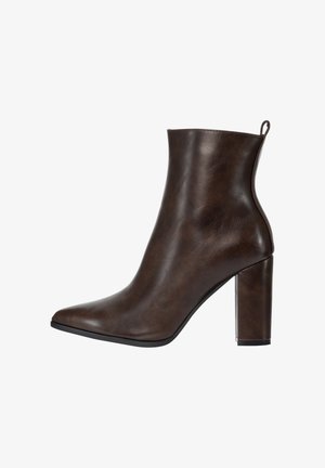 Brauner Kunstleder-Stiefelette mit spitz zulaufender Zehenpartie und Blockabsatz. Glatte Textur, Obermaterial mit elegantem Design und Lasche hinten.