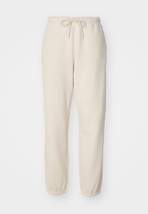 Beiget väggbyxor tillverkade av mjuk tyg, med elastisk midja och dragsko, avsmalnande anklar och en liten logotypaccent.