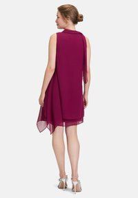 Robe sans manches en chiffon bourgogne profond. Comprend un dos fluide avec un détail noué, un ourlet superposé et des talons ouverts argentés.