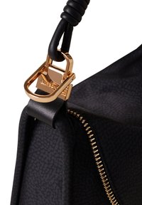 Borsa a mano in tessuto nero con superficie texture, zip dorata metallica e dettagli in oro sull'impugnatura nera.