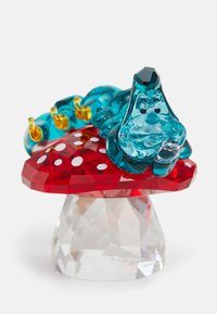 Figura di vetro di un bruco blu che riposa su un fungo rosso con pois bianchi. La base in cristallo trasparente riflette la luce.