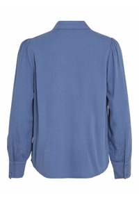 Blouse bleu à manches longues avec une texture subtile à pois, poignets boutonnés, fronces légères aux épaules et un col classique, vue de dos.