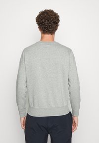 Felpa grigia con polsini e orlo a coste, realizzata in tessuto strutturato, caratterizzata da scollatura rotonda e vestibilità rilassata.