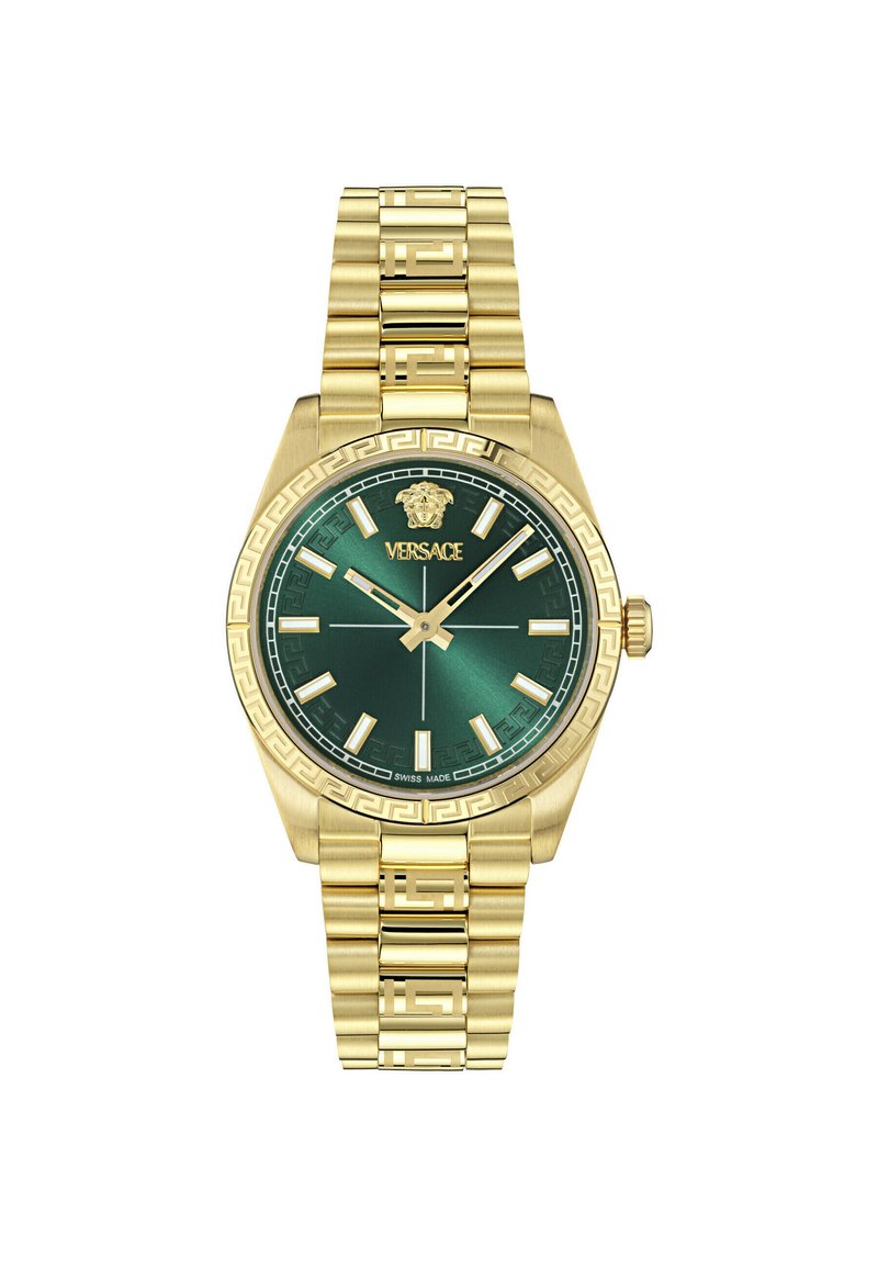 Zelta tonis pulkstenis ar zaļu metāla ciparnīcu. Iezīmē ģeometriskas stundu marķēšanas, uz bezela redzama Grieķu atslēgas raksts un saistīts zelta aproce. Šveices ražojums.