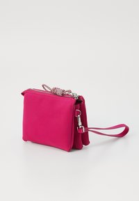 Fuchsia pink, soft-textured bag with zip closure and a striped drawstring. Features a wrist strap and compact rectangular shape.