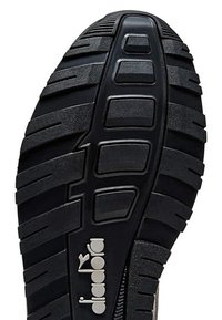 Suola di scarpa in gomma nera con un design testurizzato caratterizzato da motivi e scanalature prominenti, inclusa una logo bianco sul lato.