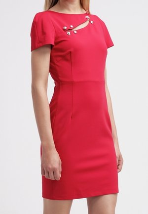 Dopasowana czerwona sukienka z krótkim rękawem, z wyciętym dekoltem ozdobionym sześcioma srebrnymi guzikami na górnej części klatki piersiowej.