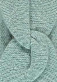 Tessuto di maglia azzurro chiaro con un motivo attorcigliato al centro, caratterizzato da una consistenza liscia e una cucitura uniforme in tutta la superficie.