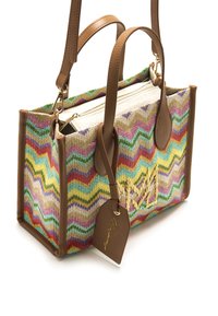 Bolso tote tejido colorido con un patrón de zigzag, detalles de cuero marrón, asas cortas y una etiqueta desmontable. Cuenta con cierre de cremallera.