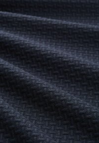Gestructureerde donkerblauwe stof met een chevronpatroon, met een zachte oppervlakte en een soepele val, geschikt voor meubelbekleding of kleding.
