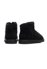 Czarne botki zamszowe za kostkę z podszyciem ze sztucznego futra, zaokrąglonym czubkiem i przeszyciami. Posiadają naszywkę z logo z tyłu oraz gumową podeszwę.