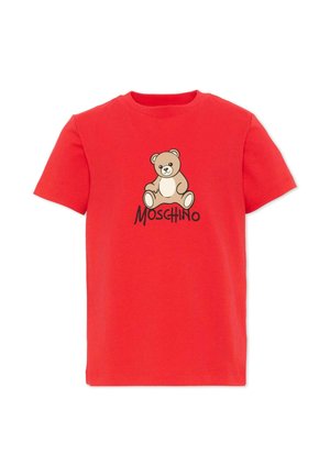 Czerwony t-shirt z krótkim rękawem z centralnie umieszczonym obrazkiem misia nad słowem Moschino czarnymi literami.