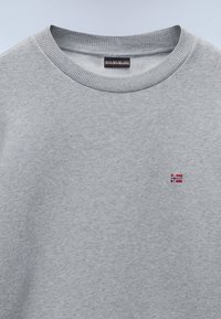 Sudadera de cuello redondo gris hecha de un tejido suave. Cuenta con un cuello acanalado y una pequeña bandera noruega bordada en el pecho.