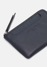 Portefeuille en cuir bleu marine avec une finition texturée, doté d'une fermeture éclair et d'un emplacement pour carte externe. Marquage en relief subtil à l'avant.