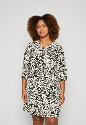Black and white zebra print dress with a V-neck, three-quarter sleeves, and a tie waist detail. Smooth fabric with a relaxed fit.