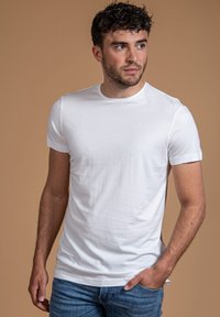 Witte katoenen t-shirt met een klassieke ronde hals, korte mouwen en een slim-fit silhouet. Minimalistisch ontwerp, soepele textuur, geen patronen.