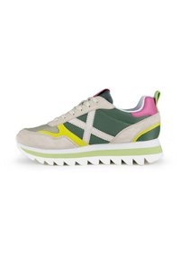 Zapatillas deportivas que combinan materiales en tonos verde, beige y rosa, con un upper de ante texturizado, suela de goma y acentos en amarillo contrastante.