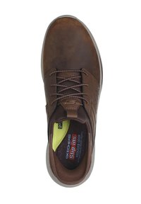 Zapato marrón de piel sin cordones con un acabado texturizado, que presenta una puntera redonda, parte delantera con cordones y una plantilla acolchada con acento amarillo.