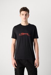 Svart bomulls t-skjorte med en rød grafikk av en løpet greyhound. Klassisk crew neck og korte ermer, glatt tekstur.