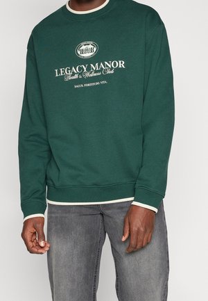 Sudadera verde de mezcla de algodón, con cuello redondo blanco, puños de canalé y logo bordado "LEGACY MANOR" en la parte frontal.